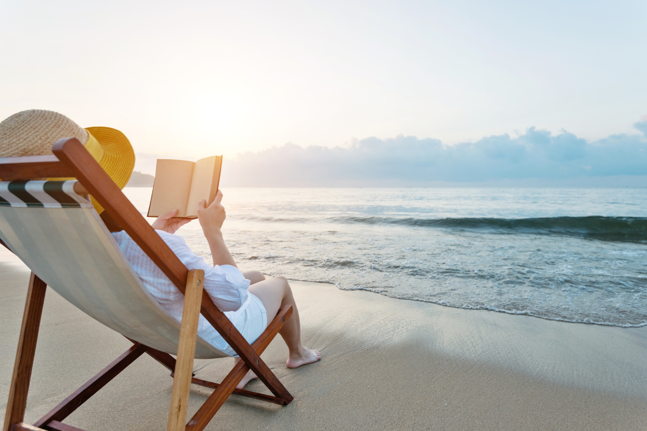 Lady on the beach reading a book